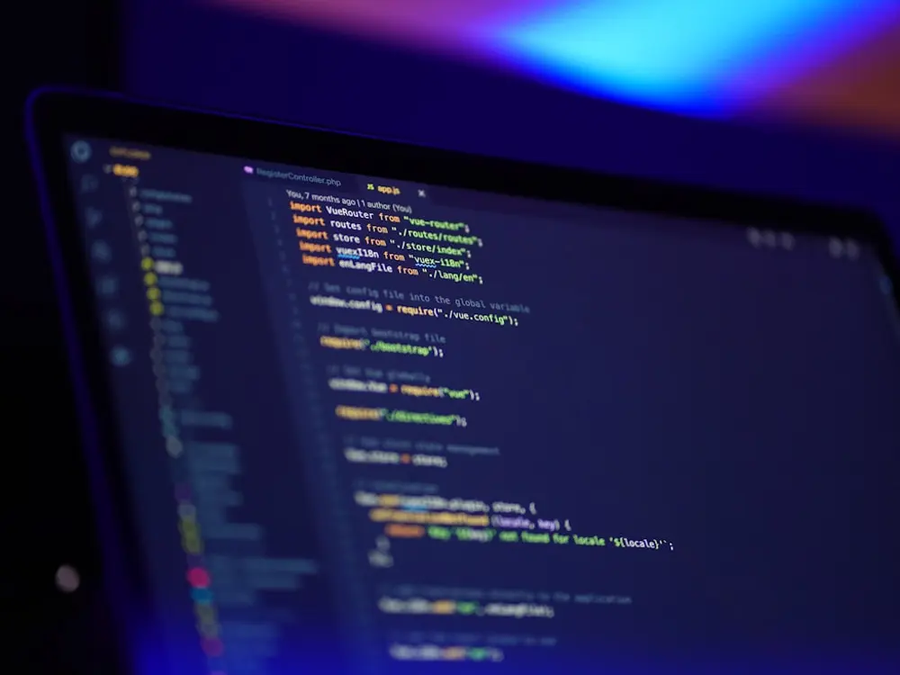 Cod afișat pe ecranul unui laptop, într-o încăpere cu lumină albastră